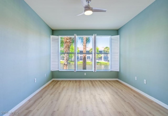 unfurnished room featuring baseboards, wood finished floors, and plenty of natural light