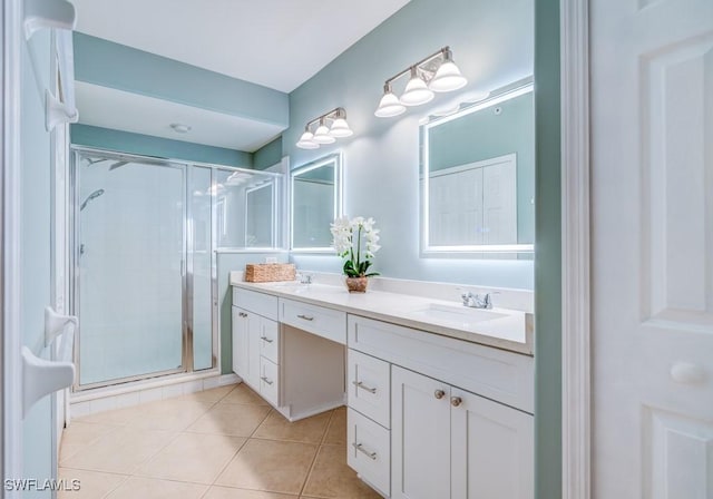 full bathroom featuring double vanity, tile patterned flooring, a stall shower, and a sink