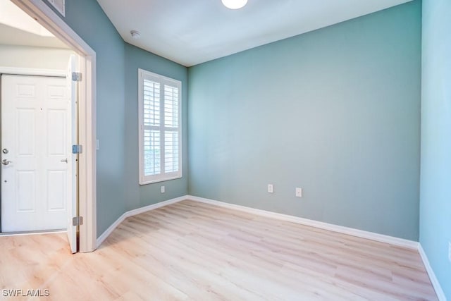 empty room featuring baseboards and light wood-style flooring