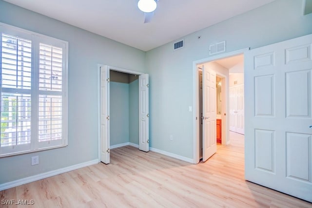 unfurnished bedroom with baseboards, visible vents, a ceiling fan, and light wood-style flooring