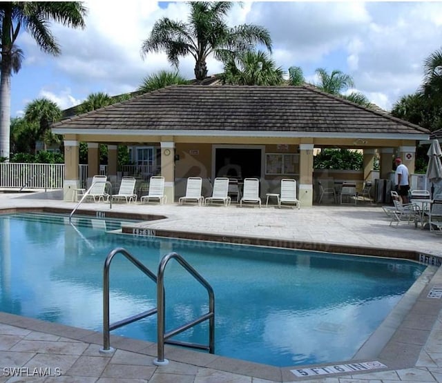 community pool featuring fence, a gazebo, and a patio area