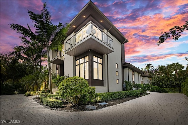 1230 Gulf Shore Blvd S, Naples, FL 34102 - property exterior at dusk featuring driveway, stucco siding, and a balcony