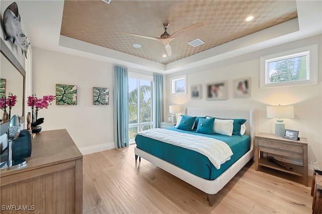 1230 Gulf Shore Blvd S, Naples, FL 34102 - bedroom with a raised ceiling, multiple windows, light wood-style flooring, and recessed lighting