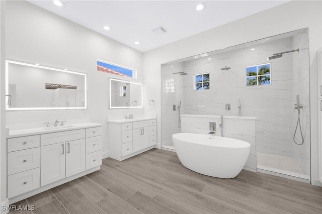 16404 Coco Hammock Way, Fort Myers, FL 33908 - full bath with a marble finish shower, two vanities, a soaking tub, recessed lighting, and wood finish floors