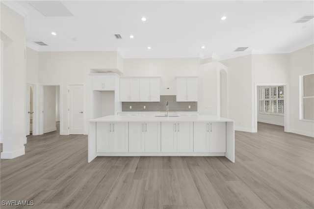 16404 Coco Hammock Way, Fort Myers, FL 33908 - kitchen featuring light countertops, white cabinets, a large island with sink, crown molding, and decorative backsplash