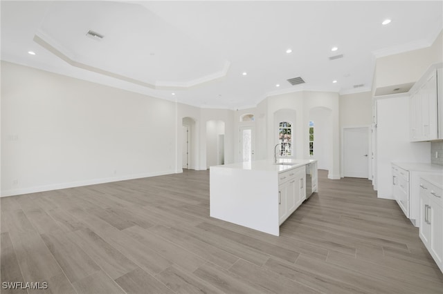 16404 Coco Hammock Way, Fort Myers, FL 33908 - kitchen featuring arched walkways, crown molding, light countertops, an island with sink, and recessed lighting