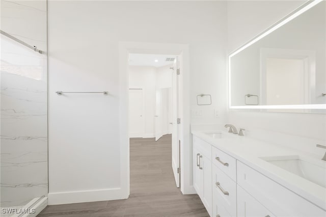 16404 Coco Hammock Way, Fort Myers, FL 33908 - bathroom with double vanity, a marble finish shower, and wood finished floors