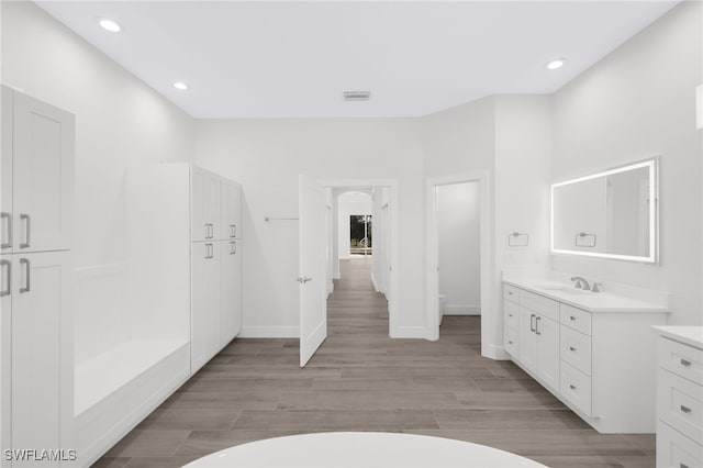 16404 Coco Hammock Way, Fort Myers, FL 33908 - bathroom featuring vanity, wood finished floors, a freestanding tub, and recessed lighting