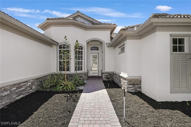 16404 Coco Hammock Way, Fort Myers, FL 33908 - property entrance featuring stucco siding, a tiled roof, and stone siding