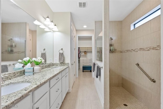 bathroom with a walk in shower, visible vents, and a sink