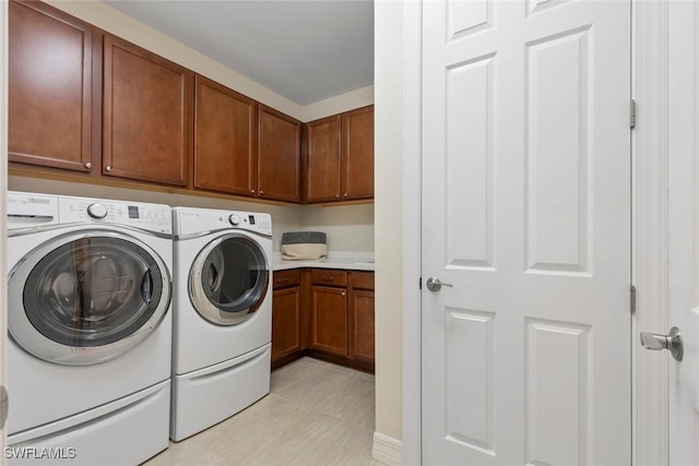 washroom with cabinet space and washer and clothes dryer