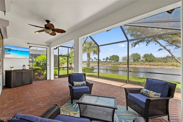 view of patio with an outdoor living space, a water view, a lanai, and a ceiling fan