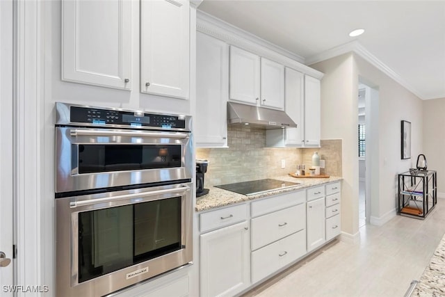 kitchen featuring decorative backsplash, crown molding, under cabinet range hood, double oven, and black electric cooktop