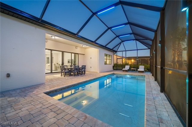 outdoor pool featuring glass enclosure, outdoor dining space, and a patio area