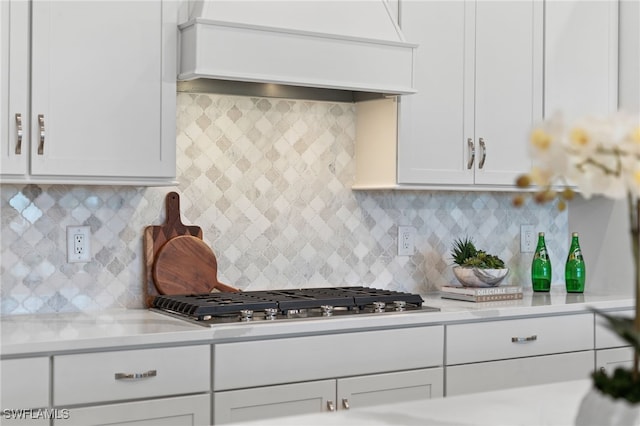 kitchen featuring stainless steel gas stovetop, white cabinets, light countertops, and premium range hood