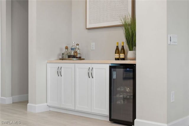 bar featuring a dry bar, beverage cooler, and baseboards