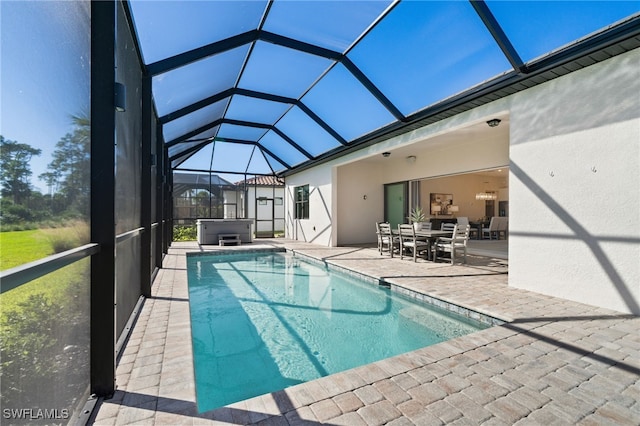outdoor pool with glass enclosure, a patio, outdoor dining space, and a hot tub