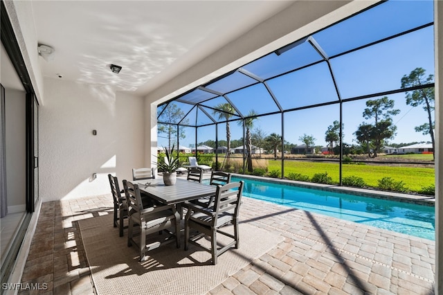outdoor pool with a yard, a patio, outdoor dining area, and a lanai
