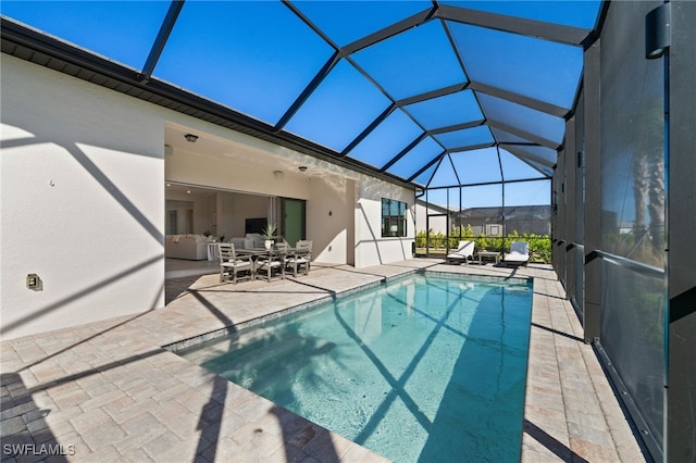 pool with glass enclosure and a patio area