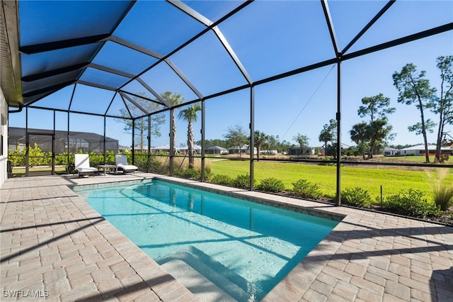 pool with a patio area, glass enclosure, and a lawn