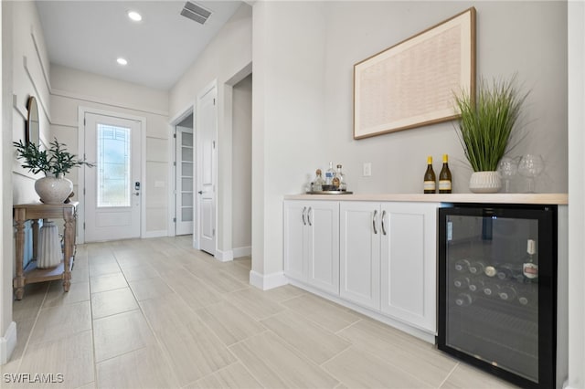 interior space featuring visible vents, baseboards, wine cooler, recessed lighting, and a bar
