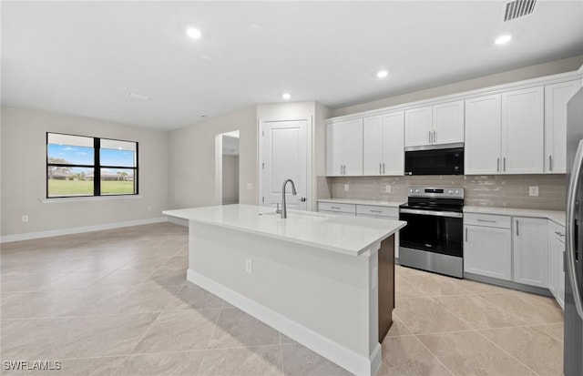 3056 Weston Manor Dr, Alva, FL 33920 - kitchen featuring a center island with sink, light countertops, decorative backsplash, electric range, and a sink
