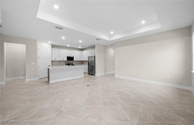 3056 Weston Manor Dr, Alva, FL 33920 - unfurnished living room featuring a sink, a tray ceiling, baseboards, and visible vents