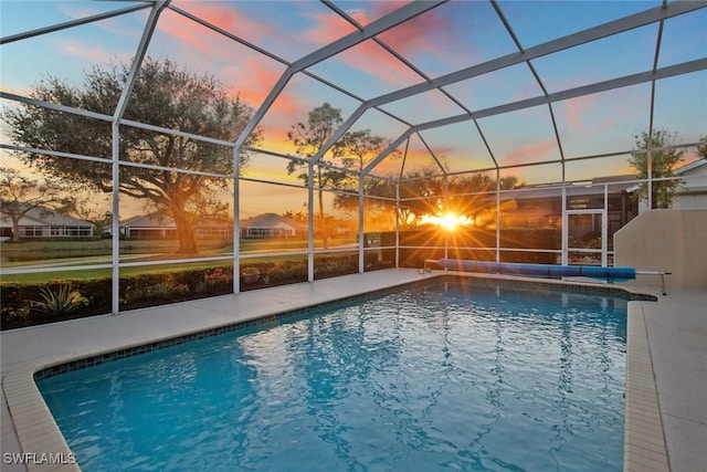 19765 Vintage Trace Cir, Estero, FL 33967 - pool at dusk with glass enclosure, an outdoor pool, and a patio