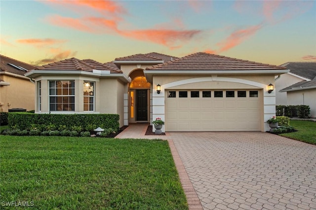 19765 Vintage Trace Cir, Estero, FL 33967 - view of front of house with stucco siding, an attached garage, a tile roof, and decorative driveway