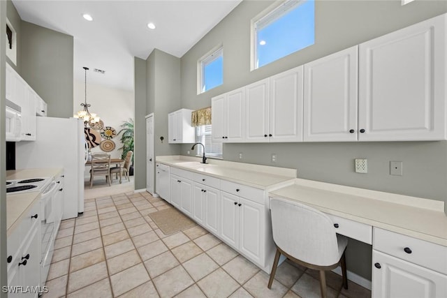 19765 Vintage Trace Cir, Estero, FL 33967 - kitchen with white cabinets, a sink, a towering ceiling, a chandelier, and white appliances
