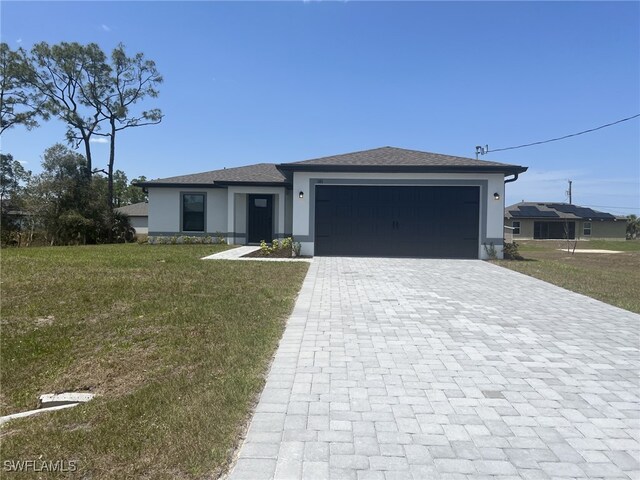 844 Gedeon Rd, Lehigh Acres, FL 33974 - view of front of house with stucco siding, a garage, decorative driveway, and a front yard