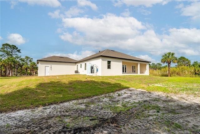 2814 26th Ave SE, Naples, FL 34117 - back of house with stucco siding and a lawn