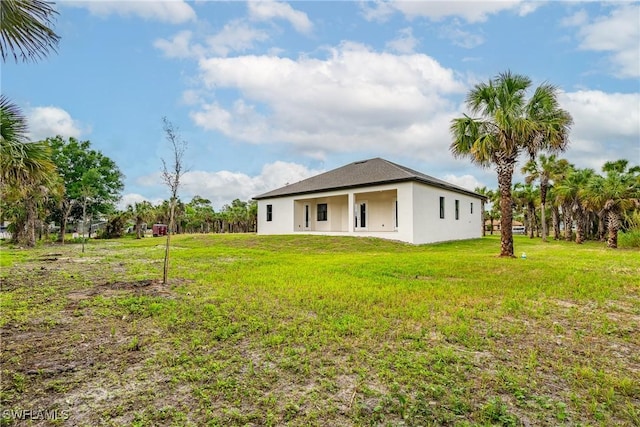 2814 26th Ave SE, Naples, FL 34117 - rear view of property with a lawn and stucco siding