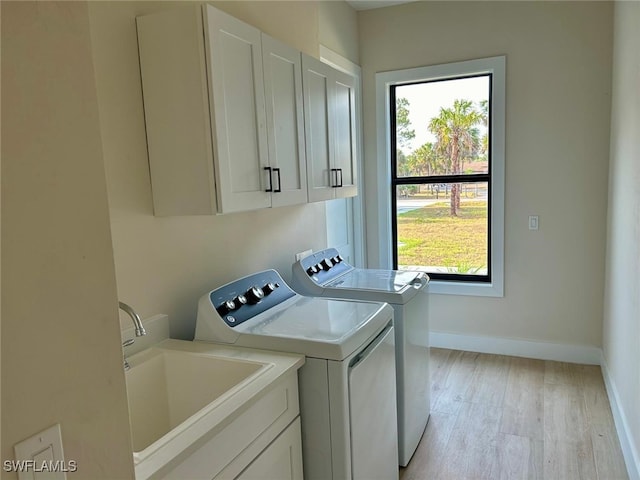 2814 26th Ave SE, Naples, FL 34117 - laundry room with separate washer and dryer, cabinet space, healthy amount of natural light, and light wood-style floors