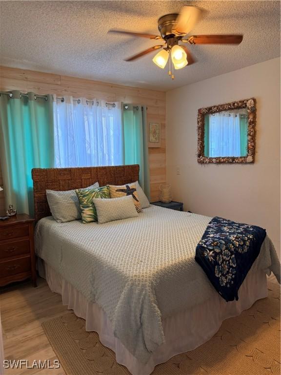 6411 Royal Woods Dr, Fort Myers, FL 33908 - bedroom featuring a ceiling fan, light wood-type flooring, and a textured ceiling