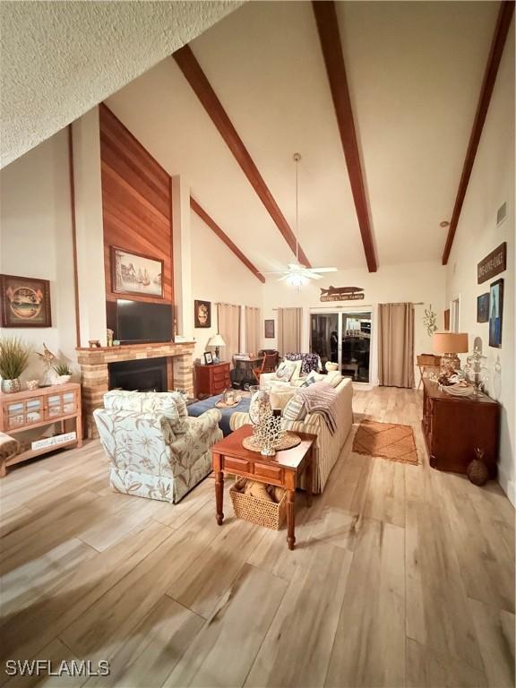 6411 Royal Woods Dr, Fort Myers, FL 33908 - living area with beamed ceiling, high vaulted ceiling, wood finished floors, and a fireplace