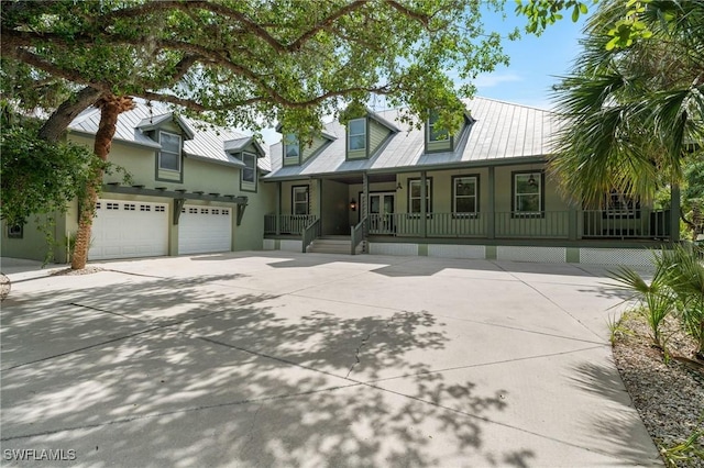 20732 Charing Cross Cir, Estero, FL 33928 - new england style home featuring driveway, a porch, stucco siding, and metal roof