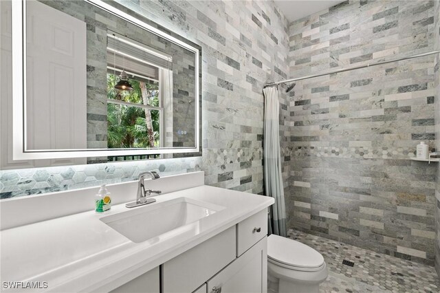 20732 Charing Cross Cir, Estero, FL 33928 - bathroom with vanity, a stall shower, toilet, and tile walls