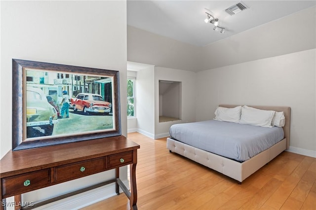 20732 Charing Cross Cir, Estero, FL 33928 - bedroom featuring light wood-style flooring, track lighting, baseboards, and lofted ceiling