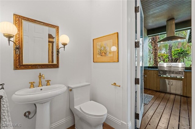 20732 Charing Cross Cir, Estero, FL 33928 - bathroom featuring hardwood / wood-style floors, toilet, and baseboards