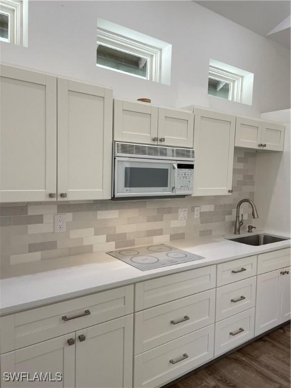 20732 Charing Cross Cir, Estero, FL 33928 - kitchen with white microwave, a sink, electric stovetop, decorative backsplash, and light countertops