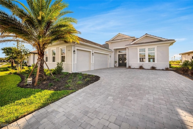 15445 Turin Dr, Naples, FL 34114 - single story home featuring decorative driveway, an attached garage, and stucco siding