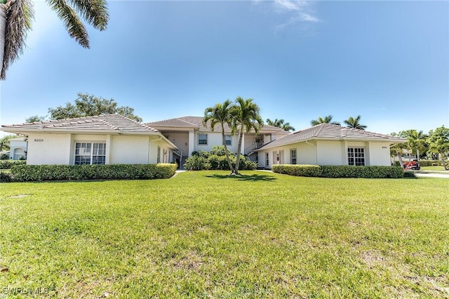 8201 Grand Palm Dr Unit 4, Estero, FL 33967 - view of front of house with stucco siding, a front yard, and a tiled roof