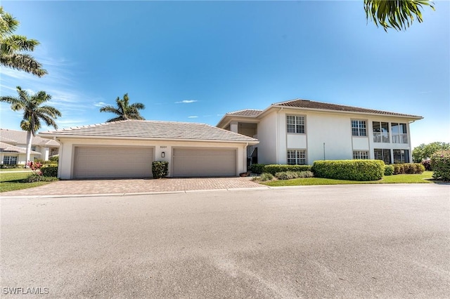 8201 Grand Palm Dr Unit 4, Estero, FL 33967 - view of front of house with decorative driveway, stucco siding, an attached garage, and a tile roof