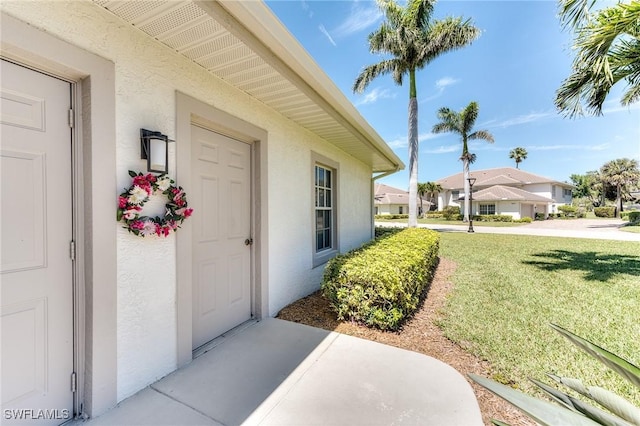 8201 Grand Palm Dr Unit 4, Estero, FL 33967 - property entrance with stucco siding, a lawn, and a residential view