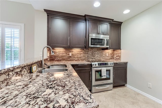8201 Grand Palm Dr Unit 4, Estero, FL 33967 - kitchen with appliances with stainless steel finishes, decorative backsplash, a sink, light stone countertops, and recessed lighting