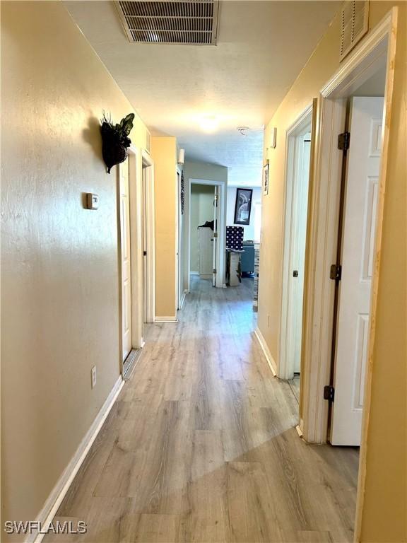 4844 Golfview Blvd, Lehigh Acres, FL 33973 - hall with baseboards, light wood-style floors, and visible vents