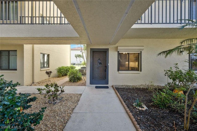 doorway to property featuring central air condition unit and stucco siding