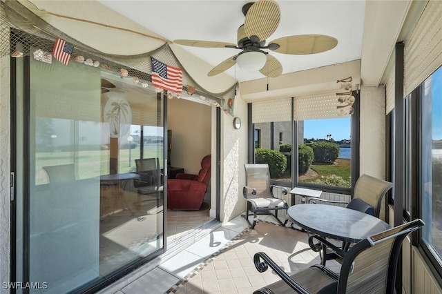 sunroom featuring ceiling fan and plenty of natural light