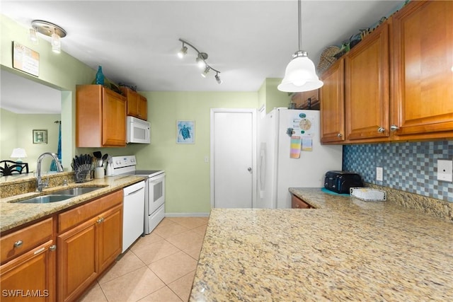 kitchen with white appliances, light stone countertops, a sink, backsplash, and light tile patterned floors